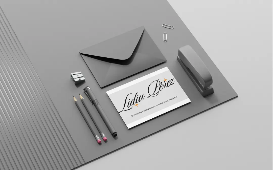 A gray envelope with the name "Julia Perez" written on it, surrounded by various office supplies such as a pen, pencil, and a smartphone on a gray background